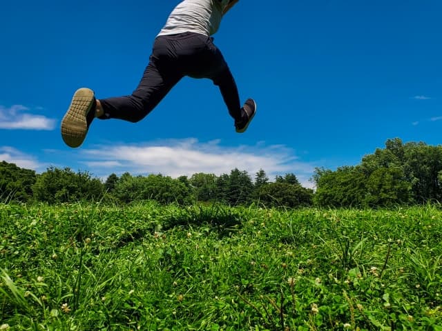 草原を走る男性