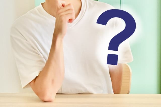 顎に手を当てて考えている男性